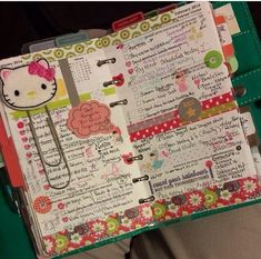 an open hello kitty planner book on a person's lap with a clipboard attached to it