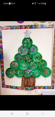 a paper plate christmas tree made out of green plates on top of a white board