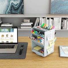 an open laptop computer sitting on top of a wooden desk next to a bookshelf