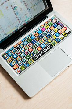 an open laptop computer sitting on top of a wooden table