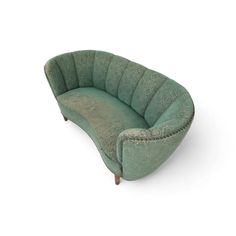 a green curved couch sitting on top of a white floor