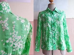 "This cotton blouse is in green cotton cotton with cute floral print. Classic 70s mod shirt collars Darts at chest Vintage Button front entry All original buttons are in place. Long sleeves. Very lightweight. Actual color may be slightly different than shown. CONDITION: very good vintage condition In Measurements(taken flat): Shoulders: 15\" Bust: 18\" Waist : 17\" Total Length: 25\" Sleeve length : 21\" Freshly cleaned and ready to wear To see more items, visit : www.RetroTheory.etsy.com" Green Collared Top With Floral Print, Green Collar Blouse For Spring, Green Collared Shirt For Spring, Green Floral Print Top With Collar, Retro Green Printed Blouse, Green Cotton Shirt With Floral Print, Green Printed Blouse For Daywear, Vintage Green Button-up Shirt, Green Floral Print Button-up Shirt