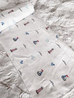 a white blanket with blue and red designs on it