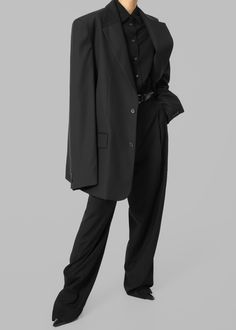 Color: Black
 Midweight traditional suiting fabric 
 Oversized tailored silhouette Padded shoulders
 Button front closure Flap front pockets Lined 65% Lyocell 25% Rayon 10% Wool
 Dry Clean By The Frankie Shop. Imported Long Sleeve Pantsuit With Button Closure For Business, Black Outerwear With Concealed Placket For Office, Tailored Black Pantsuit With Lapel Collar, Black Tailored Pantsuit With Lapel Collar, Tailored Black Pantsuit, Black Single Breasted Pantsuit For Fall, Black Single Breasted Pantsuit For Business Casual, Black Single-breasted Pantsuit For Business Casual, Black Single-breasted Pantsuit For Office