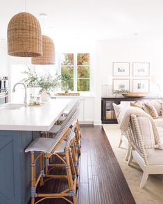 a kitchen with an island and chairs next to the counter top in front of a couch