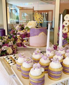 This image shows a display of cakes by lushtreatsug. Pink And Lavender Bridal Shower Ideas, Purple Dessert Cups, Lilac Bridal Shower Ideas, Lavender Bridal Shower Ideas, Purple Bridal Shower Ideas, Bridesmaid Dinner, Engagement Party Desserts, Pearl Bridal Shower, Wedding Shower Cakes