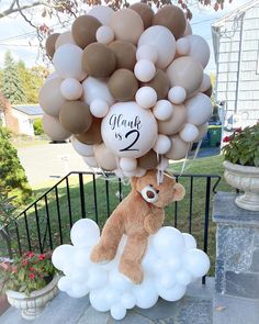 a brown teddy bear sitting on top of a bunch of white balloons with the words thank you