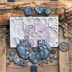 some metal hearts and gears on a wooden surface with other items around them that are made out of wood planks