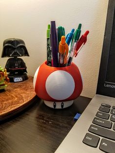 a desk with a laptop and pen holder on it