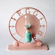 an hourglass sitting on top of a pink stand