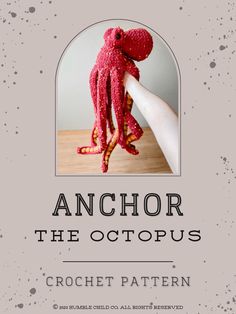 an octopus stuffed animal sitting on top of a wooden table next to a white wall