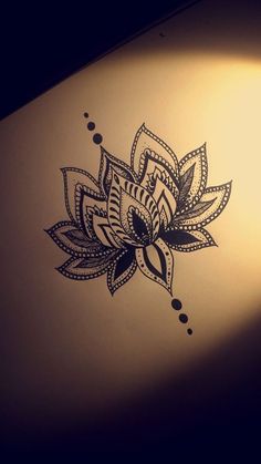 a drawing of a lotus flower on the side of a white wall with black dots