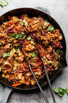 a skillet filled with chicken and veggies on top of a gray table