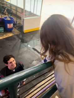 two young people are standing at the top of a railing and talking to each other