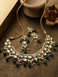 This impressive jewelry set consists of a kundan studded necklace and a pair of matching drop earrings. The beautiful necklace shown in green comes gold-plated with kundan stone studs and green & white accent beads, and secured with an adjustable drawstring closure. A pair of matching drop earrings come secured with a post and back closure. This statement piece can add impact to any outfit for any festive occasion! Product color may vary based on the monitor or screen you are using.See FAQ for m Studded Necklace, Stone Studs, White Accents, Beautiful Necklace, Beautiful Necklaces, Necklace Set, Jewelry Set, Statement Pieces, Statement Necklace