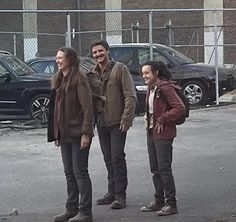 three people standing in the middle of a parking lot