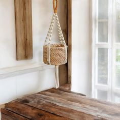 a wooden bench with a rope hanging from it's side next to a window