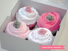 four cupcakes in a box with pink and white frosting