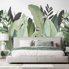 a bedroom with large green leaves painted on the wall and a bed in front of it