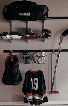 a hockey jersey hangs on the wall next to other sports equipment