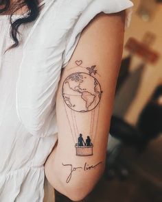 a woman with a tattoo on her arm that has a couple in a hot air balloon