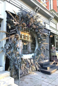 a christmas wreath on the side of a building with stairs leading up to an entrance