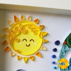 the sun is made out of paper and sits on top of a white wall next to other crafting supplies