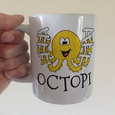 a hand holding a white coffee mug with an octopus on it's side and the words octop written in chinese