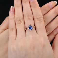 a woman's hand holding an engagement ring with a blue stone