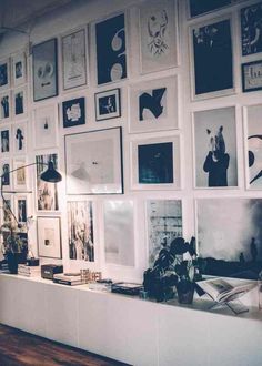 the wall is covered with many pictures and framed in black and white frames, as well as an instagram