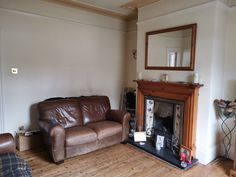 a living room with a couch, mirror and fireplace