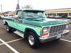 a green pick up truck parked in a parking lot