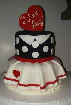 a three tiered cake with polka dots and hearts on top that says i love you