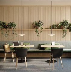 a table with four chairs and two laptops on it in front of some plants