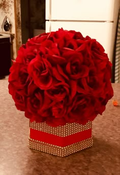 a bouquet of red roses in a box on a table