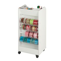 a white cabinet filled with lots of different types of ribbons and tapes on it's sides