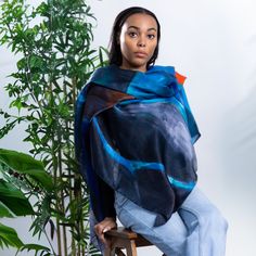 This scarf features a stunning abstract design in deep shades of blue and teal, with a bold splash of orange that evokes movement and depth, reminiscent of serene landscapes or dramatic seascapes. Its versatile styling allows it to be draped elegantly as a shawl or worn as a stylish silky top, making it a perfect choice for fashion enthusiasts. Crafted from 100% Light Satin Silk, it offers a smooth, delicate texture that feels luxuriously soft against the skin. Measuring 140 x 140 cm, it provides ample coverage and versatility. The scarf is expertly hand-hemmed, showcasing exceptional craftsmanship, and proudly made in Italy, ensuring high-quality materials and superior Italian artistry.  Dimensions: 140 x 140 cm Material: 100% Light Satin Silk Material: 100% Light Satin Silk  Dry Clean On Animal Print Party, Abstract Motif, Stocking Fillers For Him, Silky Top, Square Silk Scarf, Elegant Drapes, Stocking Fillers For Her, Fashion Enthusiast, Holiday Party Outfit