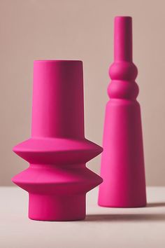 two pink vases sitting next to each other on a table