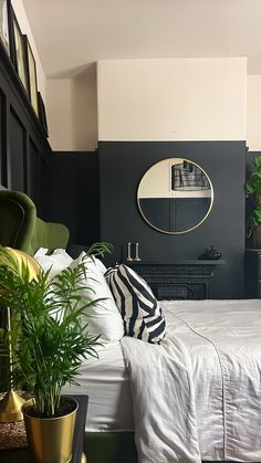 a bedroom with black walls, white bedding and potted plants in the corner