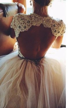 the back of a woman's wedding dress, with an intricate lace and tulle skirt