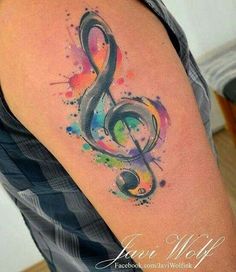 a colorful tattoo with a musical note on it's left arm and watercolor paint splatters