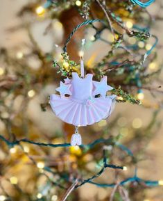 a pink ornament hanging from a tree