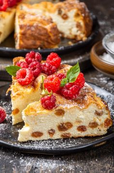 a piece of cake with raspberries is on a plate next to another slice