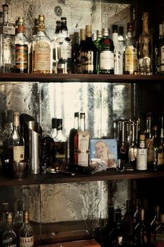 a shelf filled with lots of liquor bottles