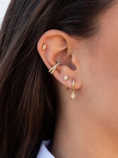 a woman wearing gold ear cuffs with diamonds