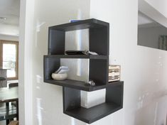 three black shelves on the wall in a living room