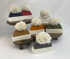 six different colored hats with pom - poms on them sitting next to each other