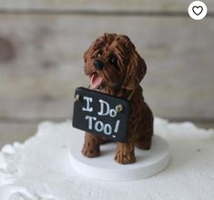 a small dog figurine holding a sign that says i do too on it