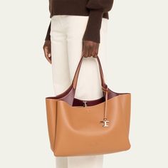 Tod's "Apa" tote bag in leather  Flat shoulder strap with logo charm  Open top with lobster clasp closure  Interior, two zip compartments  Approx. 10.2"H x 16.1"W x 7.4"D Made in Italy Luxury Tan Shoulder Bag For Everyday, Timeless Tan Shoulder Bag For Everyday Use, Tan Calf Leather Tote Shoulder Bag, Tan Calf Leather Shoulder Bag For Daily Use, Luxury Tan Shoulder Bag With Double Handle, Tan Shoulder Bag With Palladium Hardware In Calf Leather, Tan Calf Leather Shoulder Bag With Palladium Hardware, Tan Calf Leather Bag With Removable Pouch, Timeless Tan Bag With Gold-tone Hardware