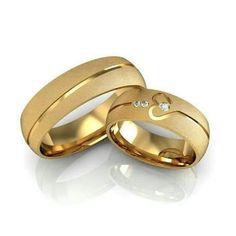 two yellow gold wedding rings with diamonds on the inside, set against a white background